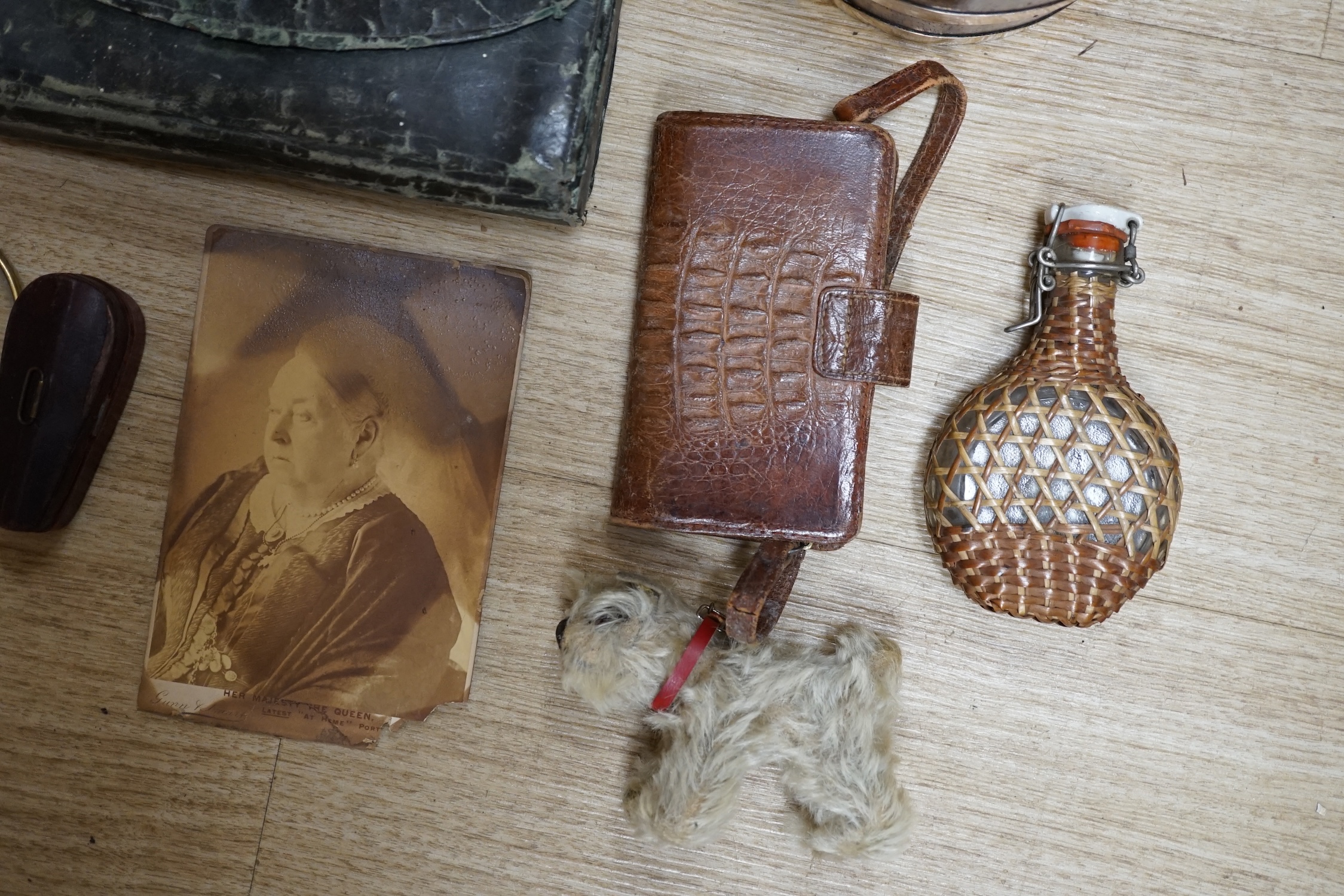 A collection of sundry items to include a fisherman's fly tying kit, a crocodile skin purse, a travelling inkwell, a miniature Steiff dog and a leather stirrup. etc. (9). Condition - mostly fair